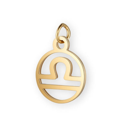 Un pendentif en or pour bola de grossesse de femme enceinte représentant le signe astrologique de la balance